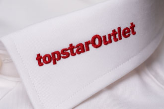 Nahaufnahme eines weißen Hemdkragens mit aufgesticktem TopstarOutlet Logo in Rot – Logo Stickerei als Beispiel für personalisierte Business- und Firmenhemden