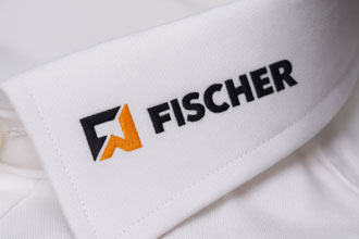 Weißer Hemdkragen mit aufgesticktem FISCHER Logo in Schwarz und Orange – Beispiel für individuelle Stickerei auf Business- und Firmenhemden